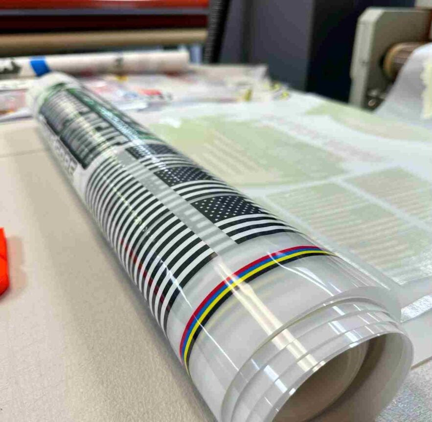 A rolled custom DTF transfer with a visible graphic design, placed on a flat surface.