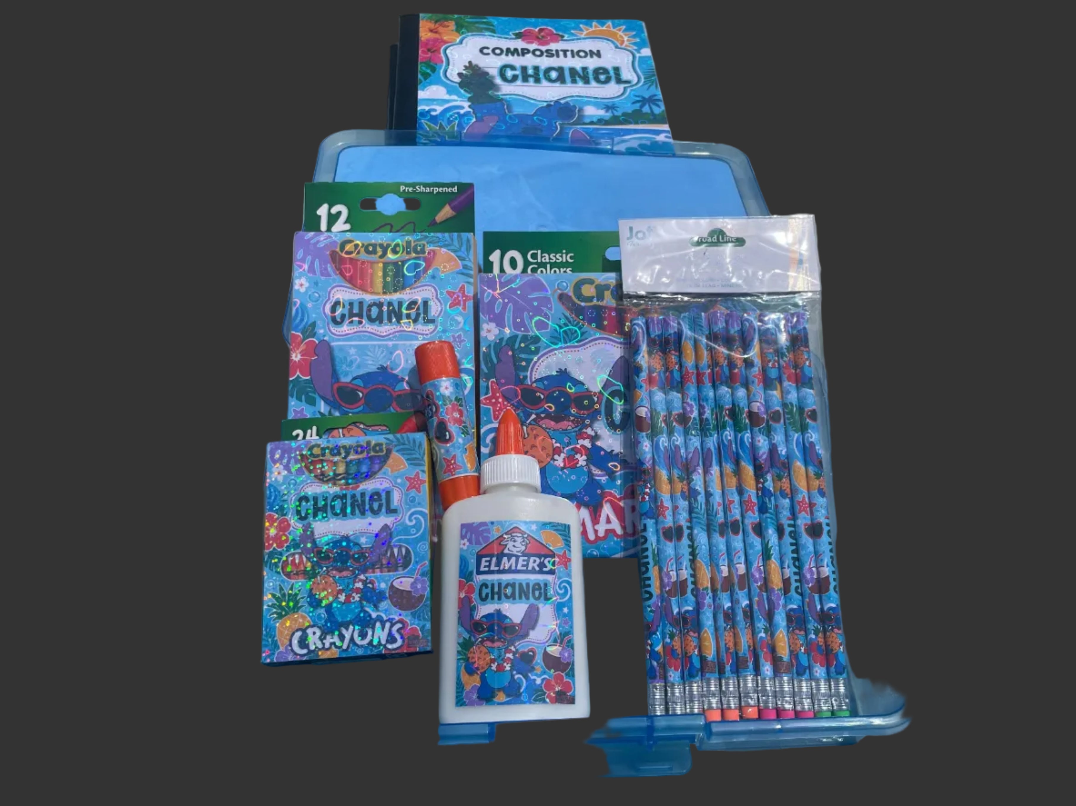 A blue plastic organizer tray filled with school supplies, including colorful patterned notebooks, a white bottle of Elmer's glue, a pack of 10 pencils, and other stationery.