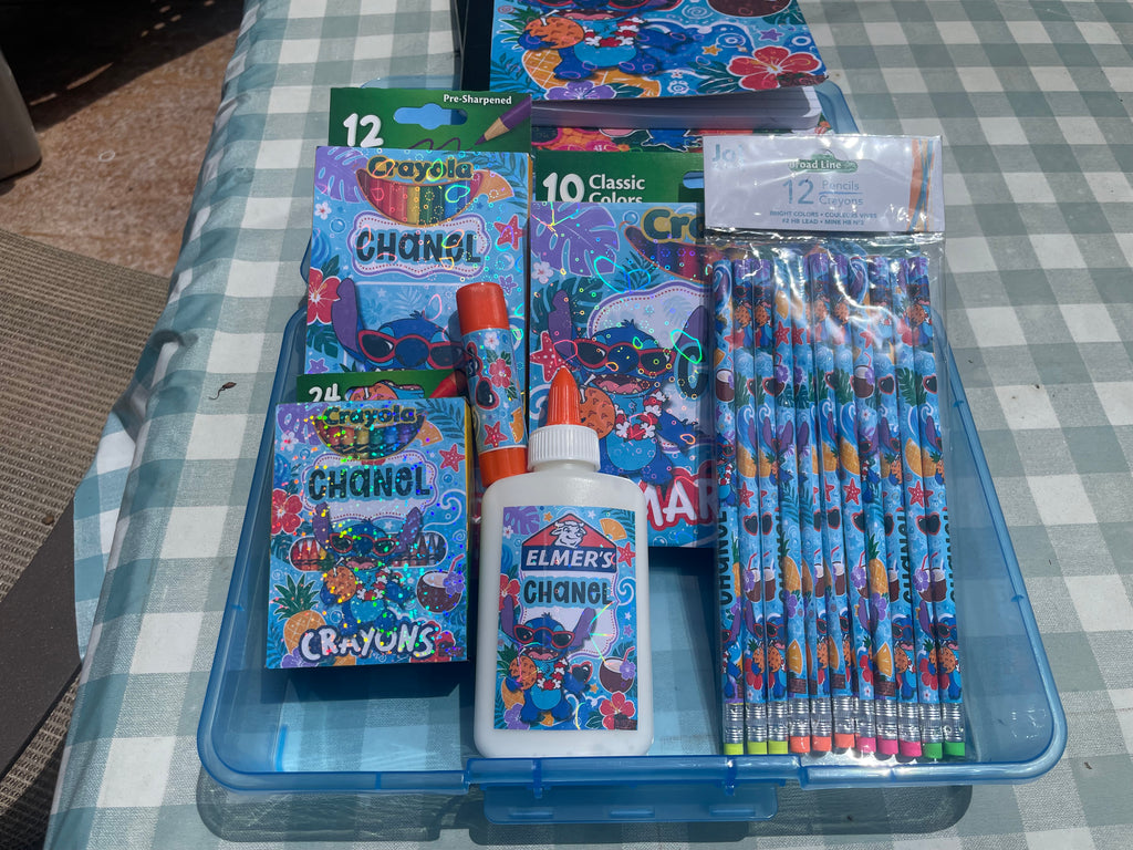 A blue plastic organizer tray holding a stationery set with Disney Stitch-themed items, including crayons, pencils, a bottle of Elmer's glue, and coloring books.