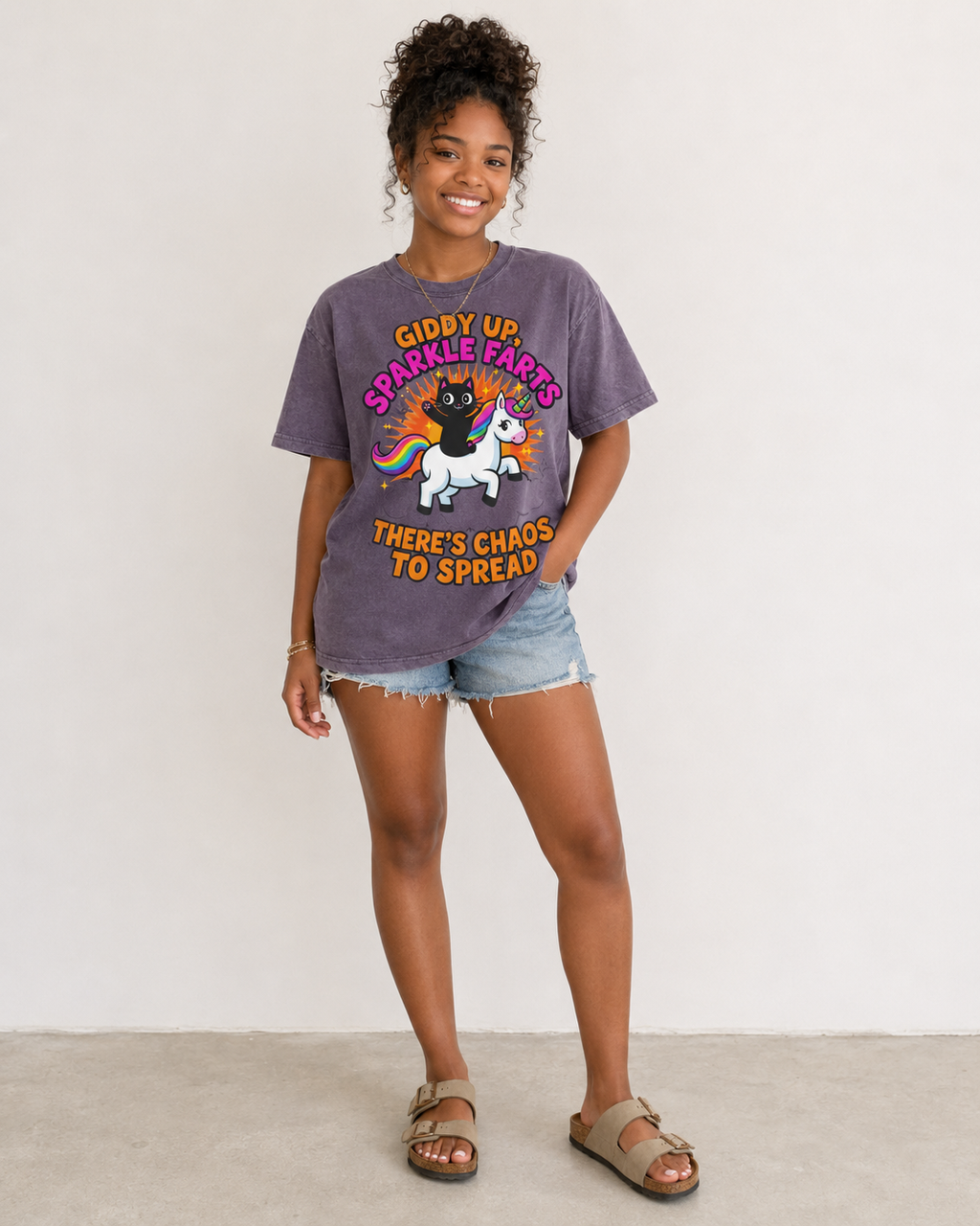 Person wearing a purple t-shirt with a colorful graphic and text, standing against a white background.